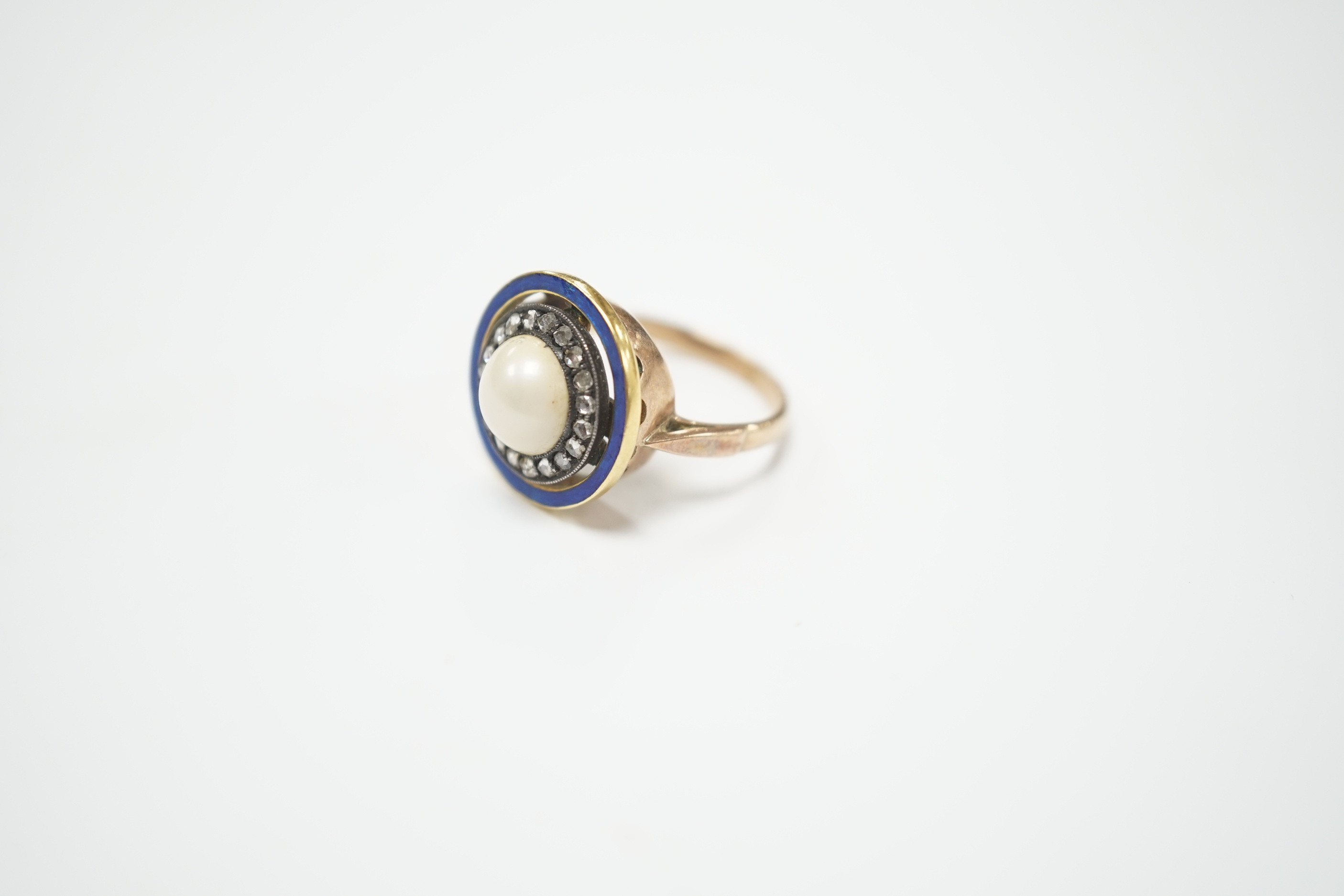 An early to mid 20th century yellow metal, split pearl, rose cut diamond chip and blue enamel set target ring, size H, ross weight 4.6 grams.